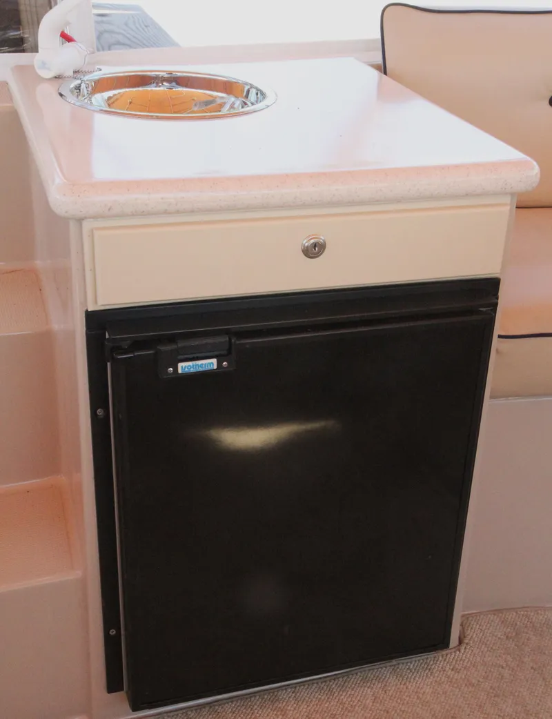 Slide: The Image of Compact kitchenette with sink and mini-fridge in 2008 Duffy Snug Harbor 18 boat. - 8