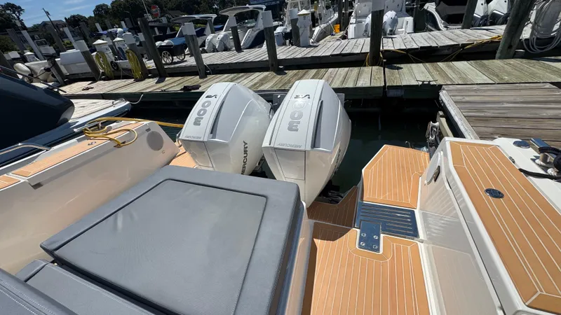 Slide: The Image of 2024 Nimbus W11 boat with twin Mercury outboard engines docked at a marina. - 12