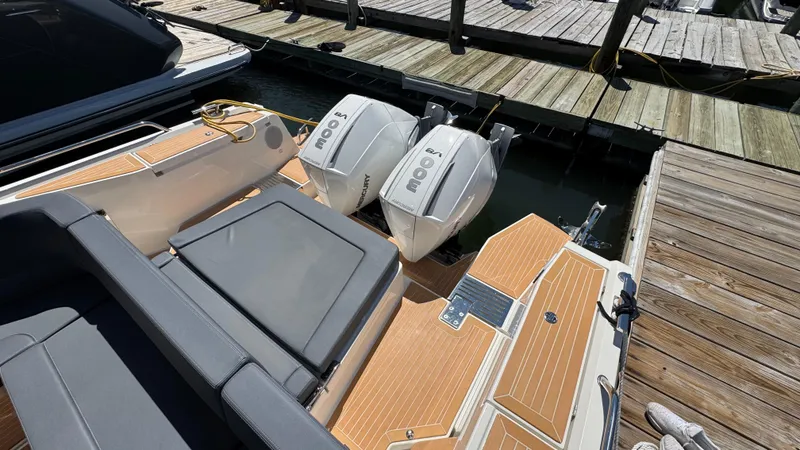 Slide: The Image of 2024 Nimbus W11 boat with twin outboard engines docked at a marina. - 13