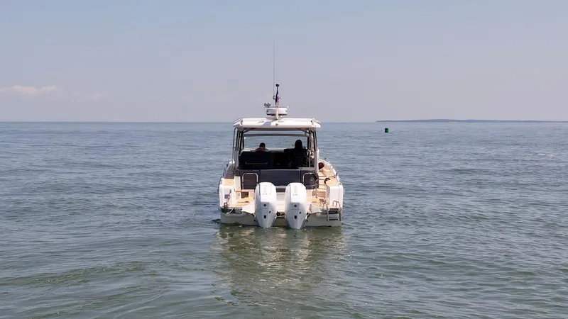 Slide: The Image of 2024 Nimbus W11 boat cruising on open water, rear view. - 2