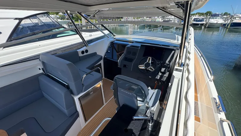 Slide: The Image of 2024 Nimbus W11 boat interior with modern helm, seating, and waterfront view. - 25