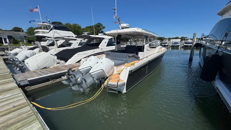 Slide: The Image of 2024 Nimbus W11 boat docked at marina, surrounded by other luxury vessels under clear blue sky. - 7
