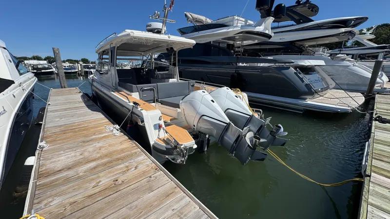 Slide: The Image of 2024 Nimbus W11 boat docked at marina, featuring dual outboard engines. - 8
