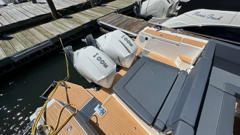 Slide: The Image of 2024 Nimbus W11 boat with twin outboard engines docked at a marina. - 9