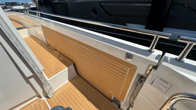 Slide: The Image of 2024 Nimbus W11 boat deck with sleek wood finish and stainless steel railings. - 14