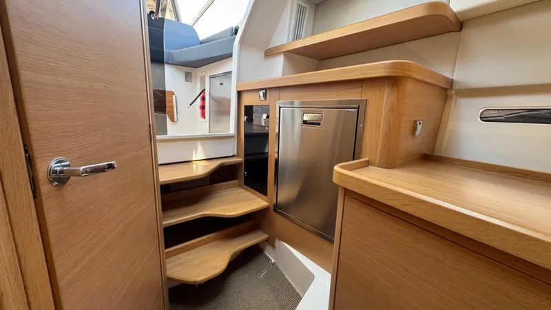 Slide: The Image of Interior of 2024 Nimbus W11 boat, featuring wooden cabinetry and modern design elements. - 28