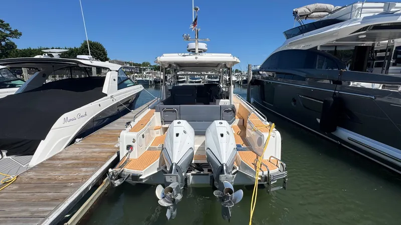 Slide: The Image of 2024 Nimbus W11 boat docked with dual outboard engines, surrounded by other yachts. - 6