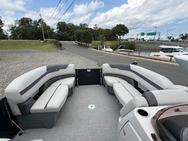 Slide: The Image of 2025 Sylvan L3 Party Fish pontoon boat with spacious seating, docked near a marina. - 11