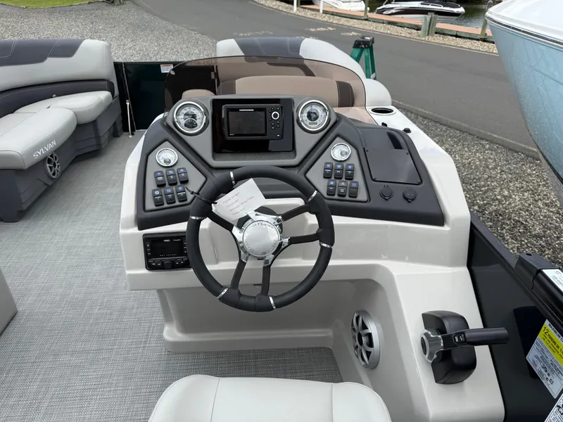 Slide: The Image of 2025 Sylvan L3 Party Fish boat dashboard with steering wheel and control panel. - 13