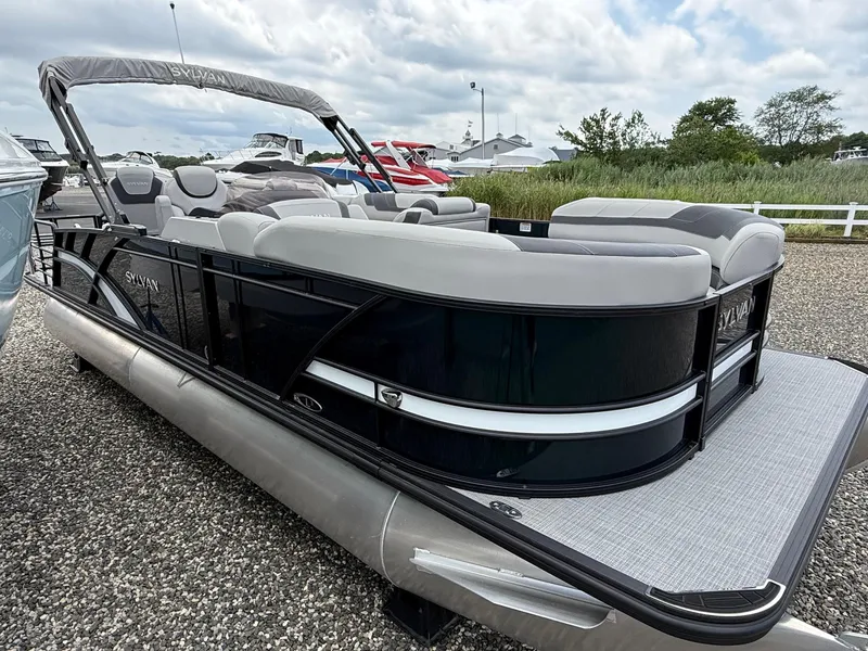 Slide: The Image of 2025 Sylvan L3 Party Fish pontoon boat with sleek design, docked outdoors. - 2
