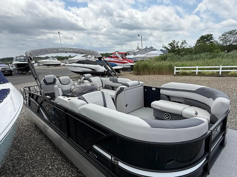 Slide: The Image of 2025 Sylvan L3 Party Fish pontoon boat with spacious seating, docked under cloudy skies. - 3