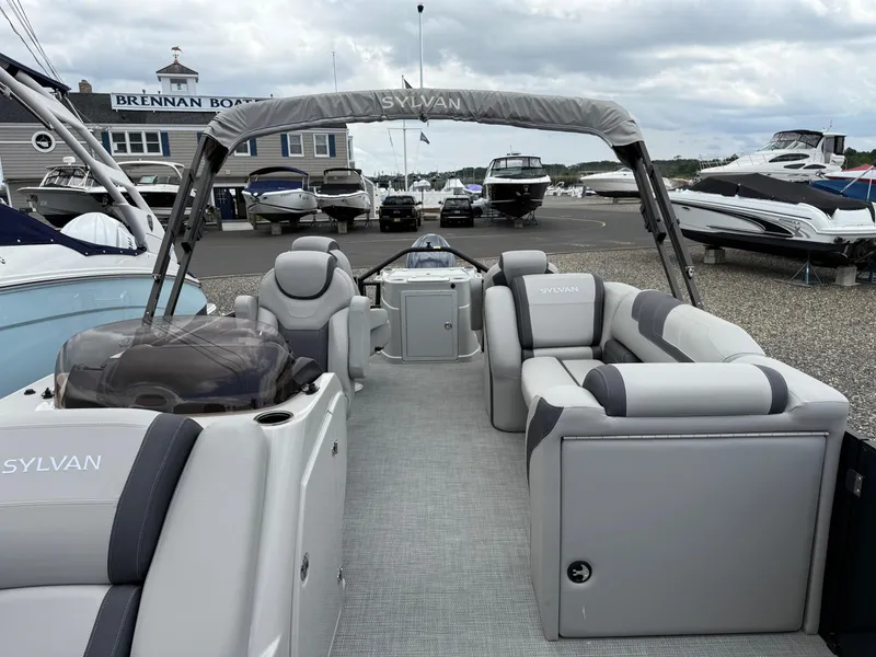 Slide: The Image of 2025 Sylvan L3 Party Fish pontoon boat with luxurious seating at a marina. - 9
