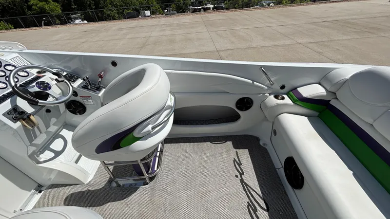Slide: The Image of 2005 Baja 33 Outlaw boat interior with white seating and modern dashboard. - 11