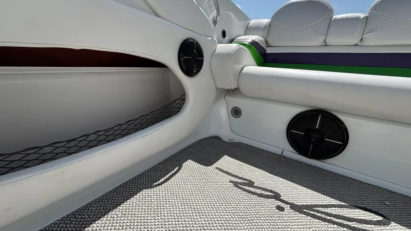 Slide: The Image of Interior of a 2005 Baja 33 Outlaw boat, featuring white seating and speaker system. - 15