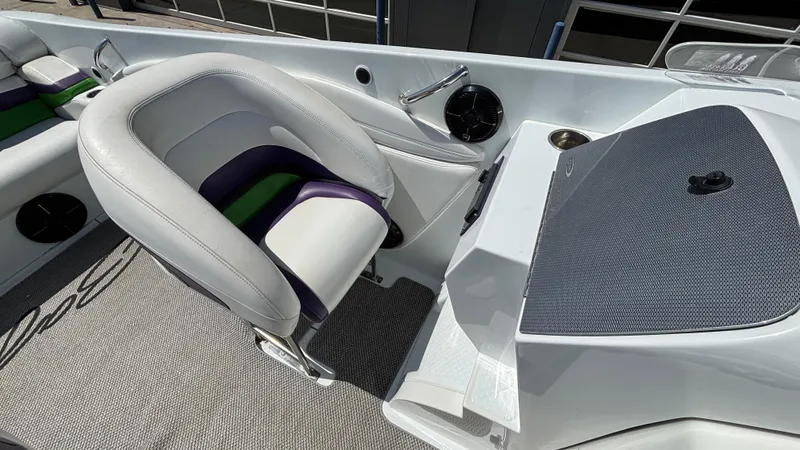 Slide: The Image of 2005 Baja 33 Outlaw boat interior with white and purple seating, modern dashboard. - 21