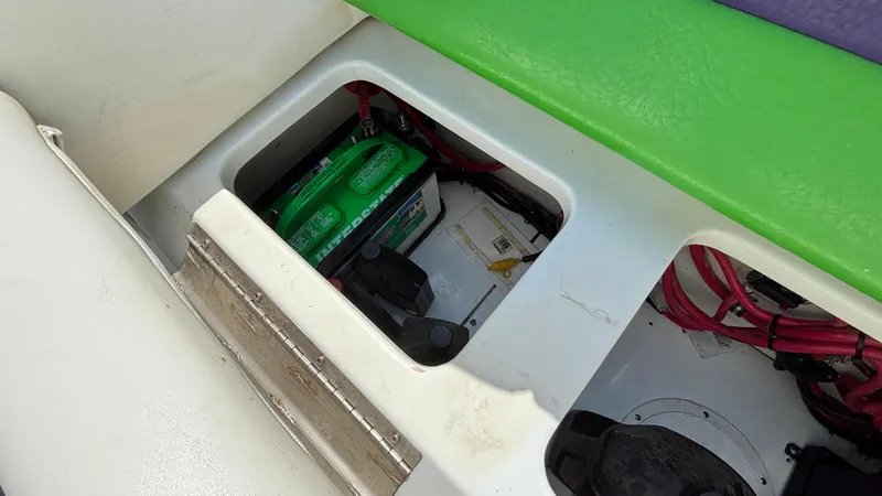 Slide: The Image of Battery compartment of a 2005 Baja 33 Outlaw boat with green and white interior. - 24
