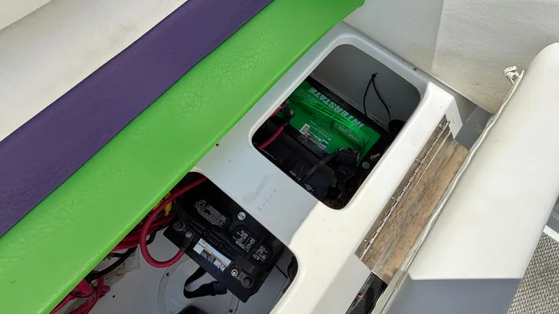 Slide: The Image of 2005 Baja 33 Outlaw boat battery compartment with colorful seating. - 26