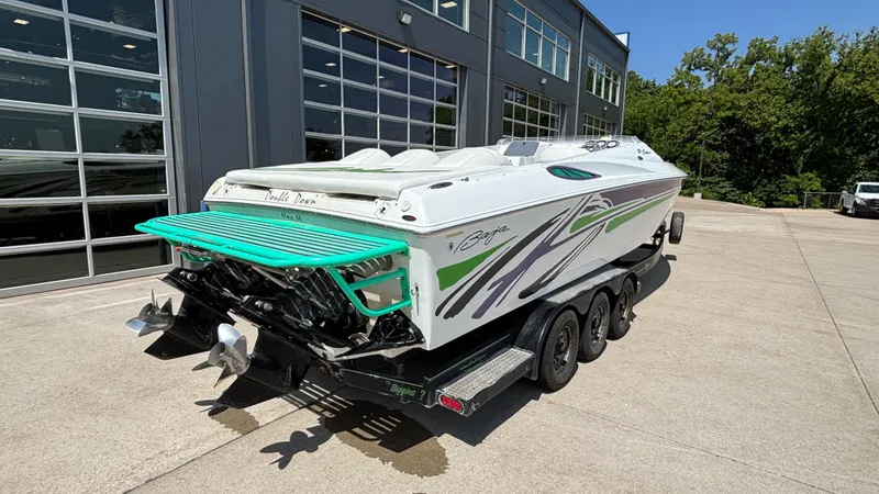 Slide: The Image of 2005 Baja 33 Outlaw boat on trailer, parked outside a modern building. - 3