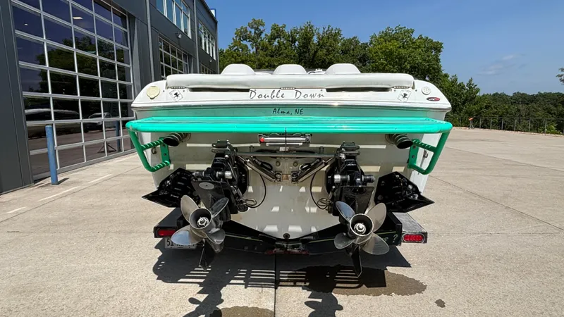 Slide: The Image of 2005 Baja 33 Outlaw boat rear view with dual propellers, parked outdoors. - 4