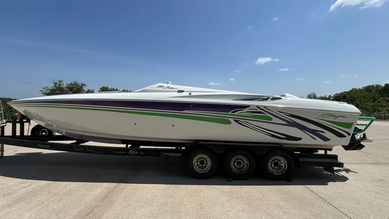 Slide: The Image of 2005 Baja 33 Outlaw speedboat on trailer, featuring vibrant purple and green graphics. - 6