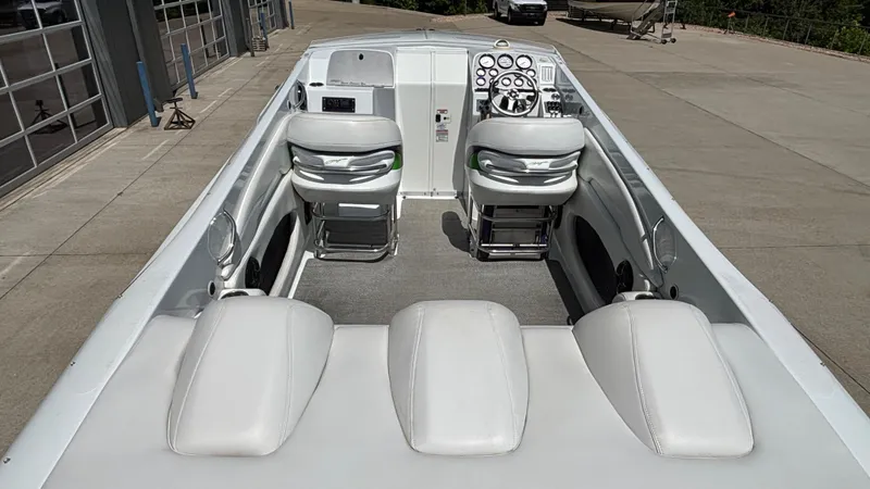 Slide: The Image of 2005 Baja 33 Outlaw boat interior with white seating and modern dashboard. - 9