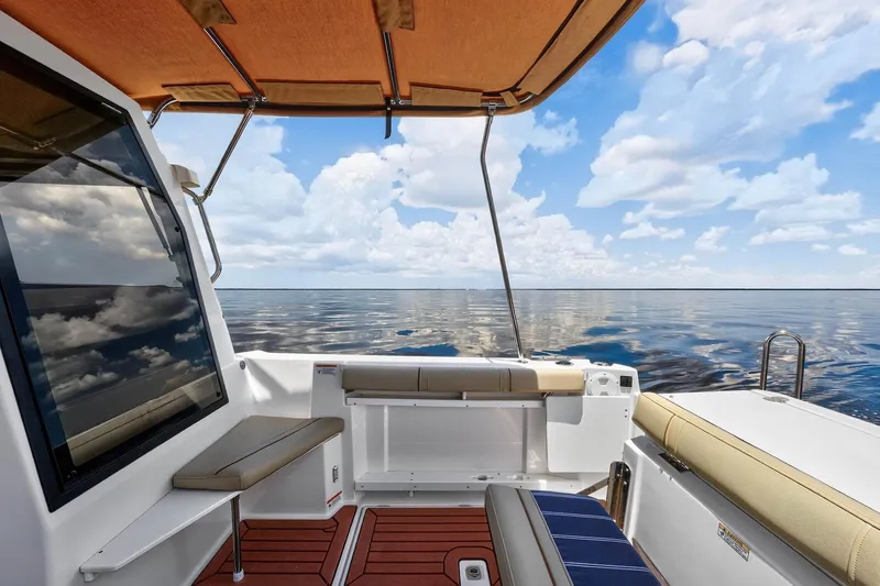 Slide: The Image of 2024 Ranger Tugs R-27 boat interior with ocean view, featuring seating and canopy. - 19