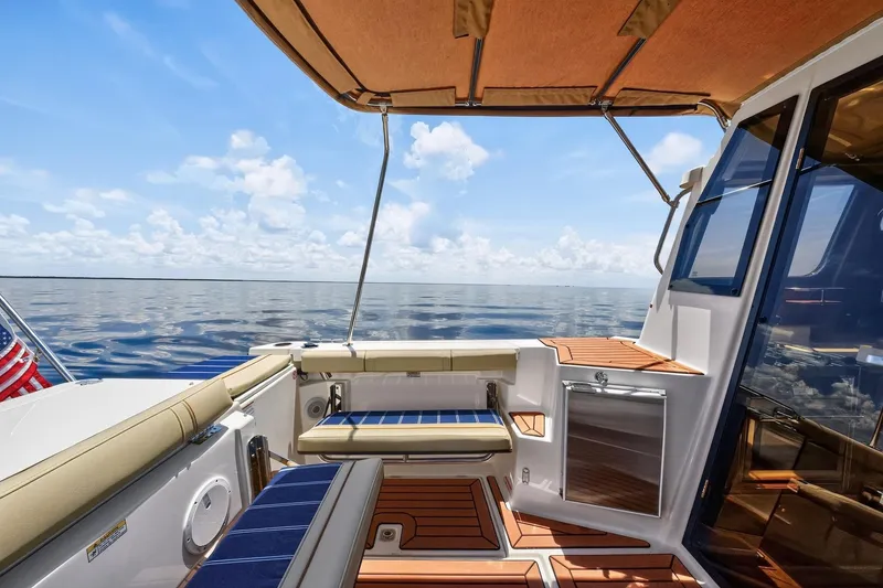 Slide: The Image of 2024 Ranger Tugs R-27 boat deck with seating, canopy, and ocean view. - 20