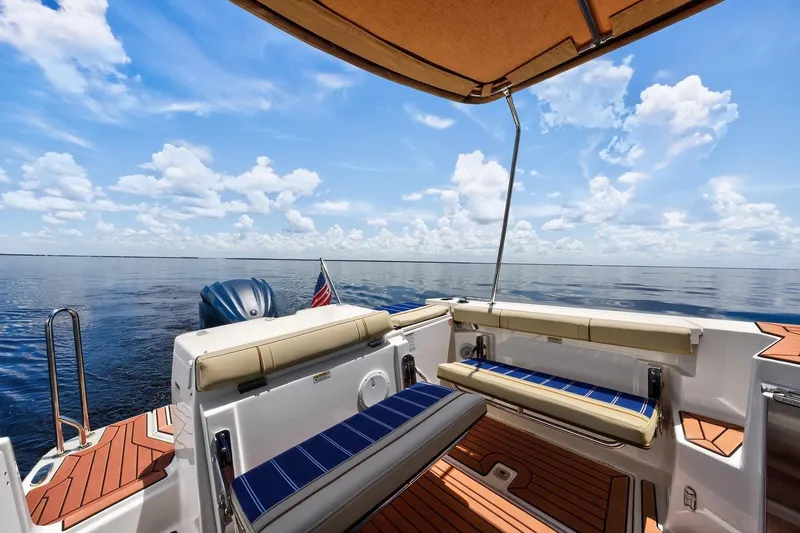 Slide: The Image of 2024 Ranger Tugs R-27 boat interior with ocean view, featuring seating and canopy. - 22