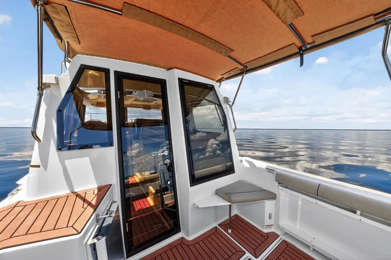 Slide: The Image of 2024 Ranger Tugs R-27 boat interior with glass doors and ocean view. - 23