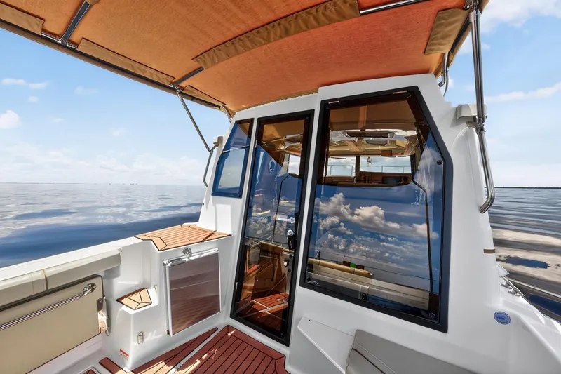 Slide: The Image of 2024 Ranger Tugs R-27 boat interior with glass doors and ocean view. - 24