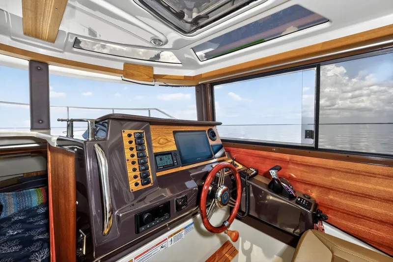 Slide: The Image of 2024 Ranger Tugs R-27 helm with modern controls and panoramic water view. - 36