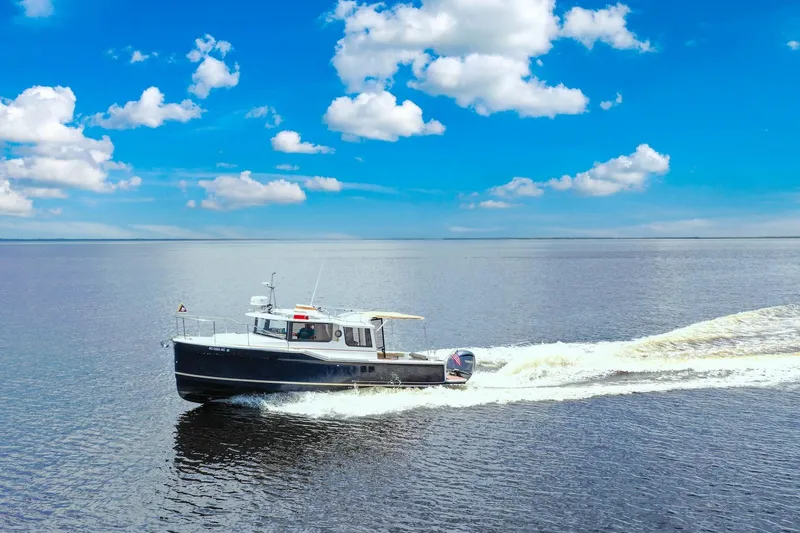 Slide: The Image of 2024 Ranger Tugs R-27 cruising on open water under a clear blue sky. - 4