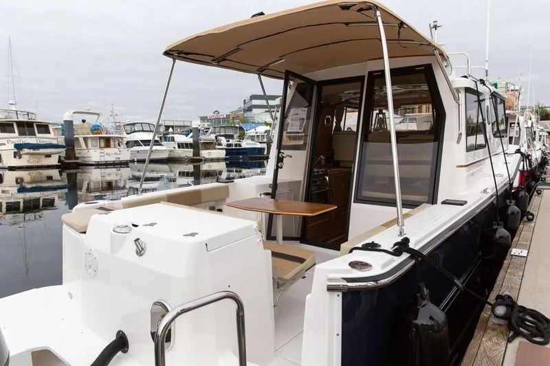 Slide: The Image of Manufacturer Provided Image: 2024 Ranger Tugs R-27 docked at a marina, showcasing its spacious deck and modern design. - 58