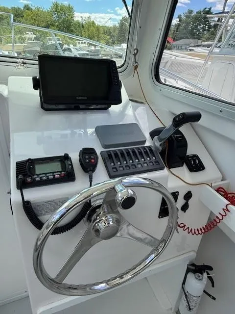 Slide: The Image of Helm of 2020 Steiger Craft 23 Miami boat with steering wheel, controls, and navigation equipment. - 6
