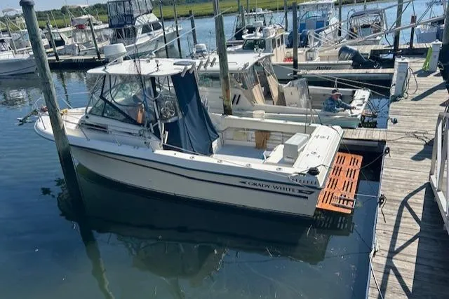 The Image of 1983 Grady-White TrophyPro boat docked at a marina, surrounded by other vessels. - 1