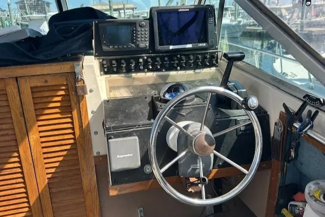 Slide: The Image of 1983 Grady-White TrophyPro boat helm with steering wheel, navigation equipment, and wooden paneling. - 5