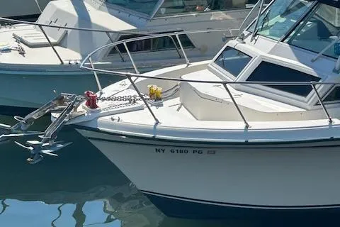 Slide: The Image of 1983 Grady-White TrophyPro boat docked in marina, featuring anchor and railings. - 7