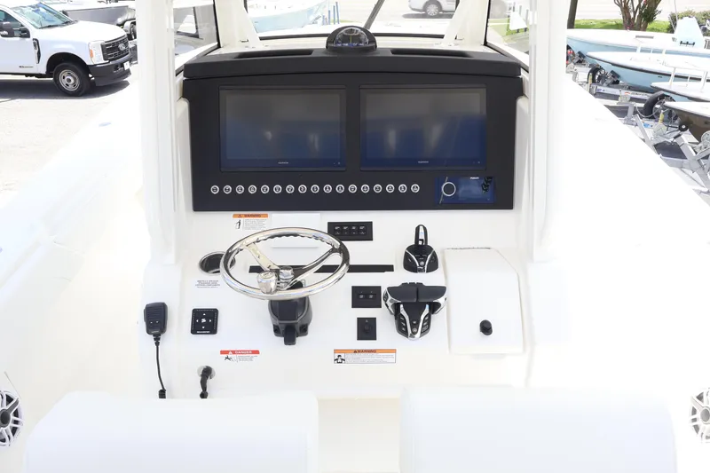 Slide: The Image of 2025 Regulator 31 boat dashboard with dual screens and steering wheel. - 12