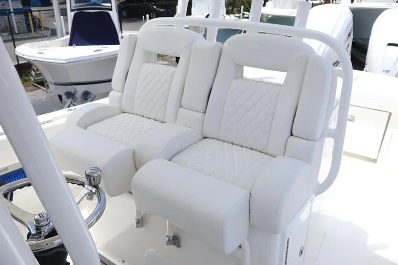 Slide: The Image of Luxury white seating on 2025 Regulator 31 boat, featuring quilted design and steering wheel. - 15