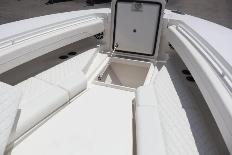 Slide: The Image of 2025 Regulator 31 boat interior with open storage compartment and cushioned seating. - 4
