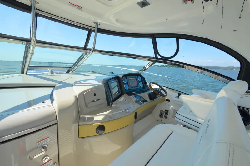 Slide: The Image of 2008 Sea Ray 44 Sundancer helm with navigation equipment, overlooking serene waters. - 12