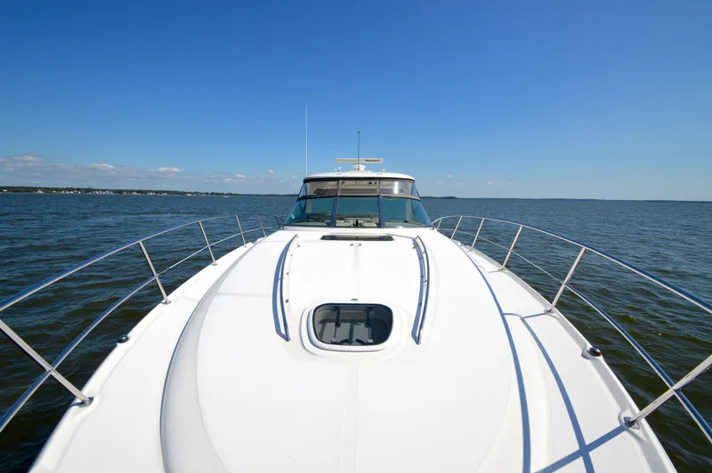 Slide: The Image of 2008 Sea Ray 44 Sundancer yacht cruising on open water under clear blue sky. - 21