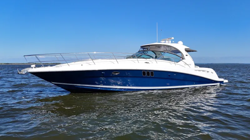 Slide: The Image of 2008 Sea Ray 44 Sundancer yacht cruising on open water under clear blue sky. - 3
