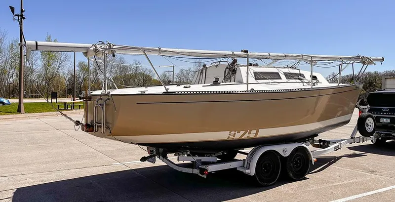 Slide: The Image of 1982 S2 7.9 sailboat on trailer in parking lot, clear sky background. - 14