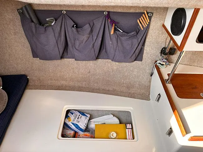 Slide: The Image of Interior of 1982 S2 7.9 sailboat with storage compartments and organized items. - 18