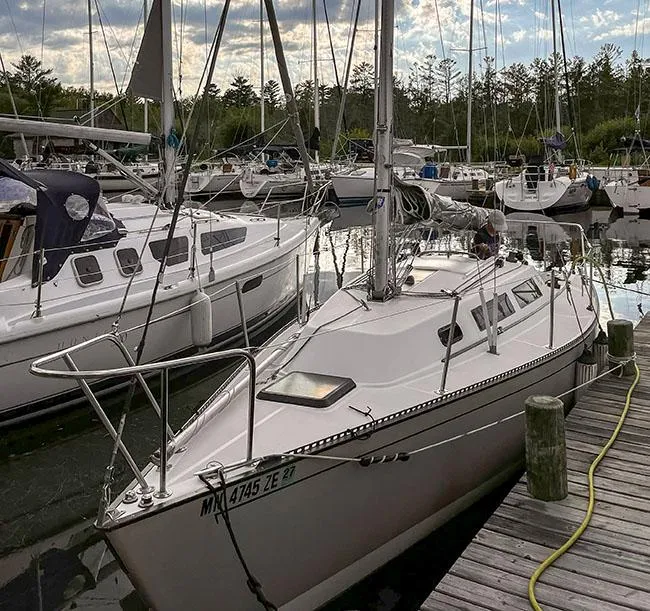 Slide: The Image of 1982 S2 7.9 sailboat docked in a marina, surrounded by other boats. - 7
