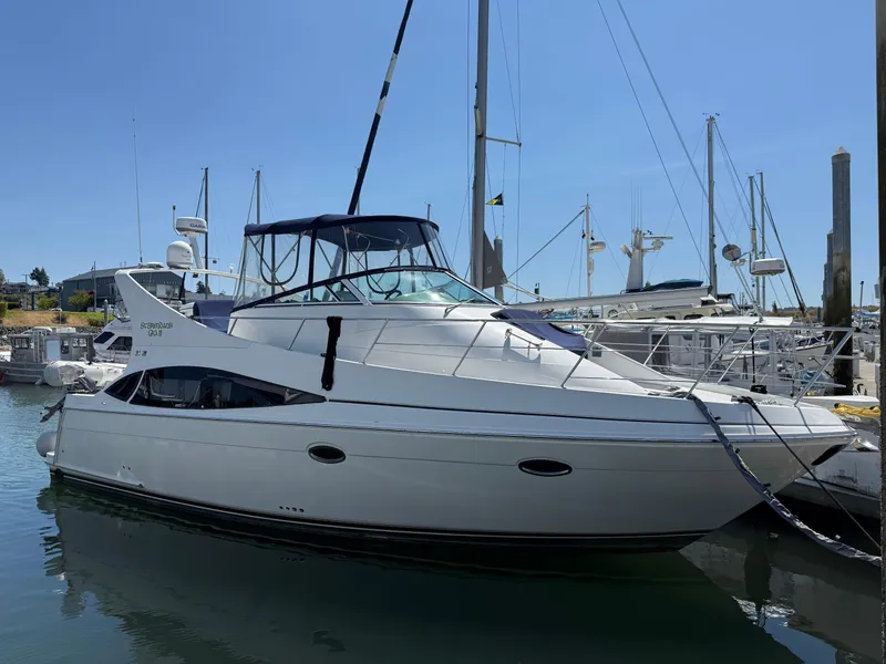 Slide: The Image of 2006 Carver 36 Mariner yacht docked at marina under clear blue sky. - 0