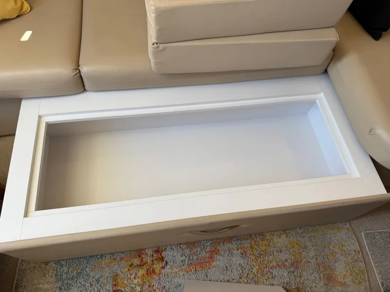 Slide: The Image of Open storage compartment on a 2006 Carver 36 Mariner boat, beige seating, colorful rug. - 29