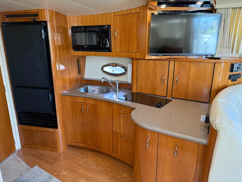 Slide: The Image of Interior of 2006 Carver 36 Mariner yacht with kitchenette, TV, and wood cabinetry. - 34