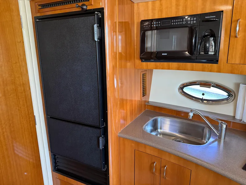 Slide: The Image of 2006 Carver 36 Mariner kitchen with fridge, microwave, sink, and wooden cabinetry. - 35